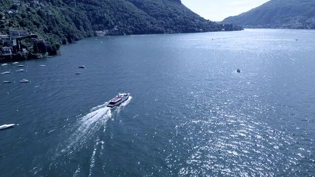 breathtaking tracking shot of aerial view of fast motorboats and slow old boats crossing themselth on water Como lake on a summer morning 6