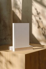 A white book sitting on top of a wooden block.