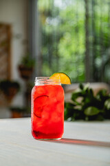 refreshing red summer raspberry lemonade drink with blurred casual background and space for text and copy	
