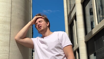 tired sick exhausted man is suffering from hot Summer heat stroke, sunshine, hot weather day,...