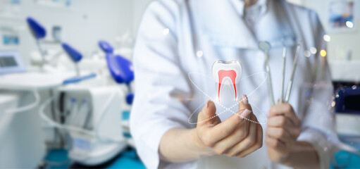 The dentist shows a tooth with an instrument in his hand .