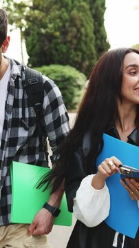 Diverse students using smartphone in park, enjoying outdoor time and learning together. Multicultural students strolling in park, engrossed in smartphone