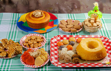 Festa Junina, beautiful rustic table with dishes containing various types of sweets for Festa Junina in Brazil, selective focus.