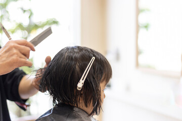 Naklejka premium 美容院でヘアカットする女の子の後ろ姿（3歳、日本人、ショートヘア）