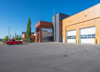 Obraz premium Red vintage pickup truck parked outside of a fire station in Calgary, Alberta, Canada