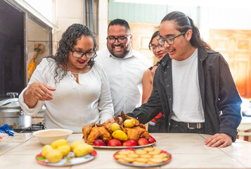 Latin family happily preparing dinner together in the kitchen.