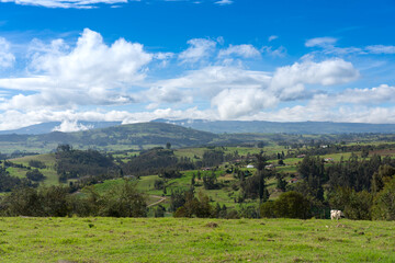 Colombian landscape of farms with crops and mountains in the background.