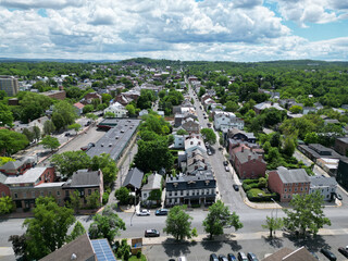 aerial view of hudson, new york (small hudson valley town city downtown historic district) mountains catskills ny travel destination main street with hills clouds cars tree matter