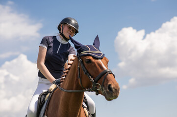 Portrait of a girl jockey riding a horse. 