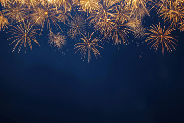 Golden fireworks exploding in the night sky creating a festive border with copy space
