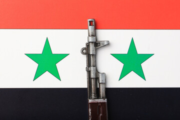 A toy gun is placed on Syria flag