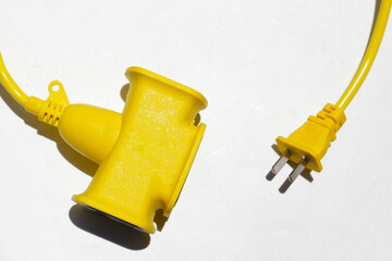 Yellow electric power cable with plug and socket on white background.