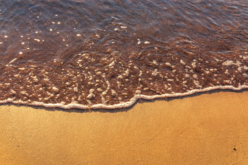 Soft wave of the sea on the sandy beach.