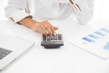 Real estate agent working with laptop at table in office.hand using laptop and calculator