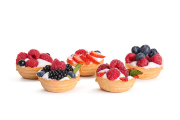 Tasty tartlets with whipped cream and berries on white background