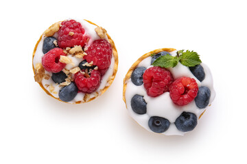 Tasty tartlets with whipped cream and berries on white background