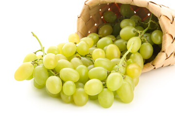 Wicker basket with fresh green grapes on white background