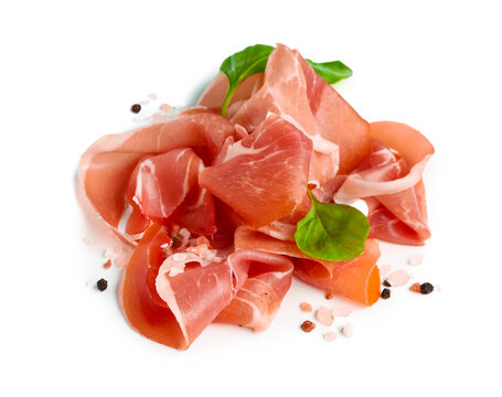 Slices of tasty prosciutto with basil on white background