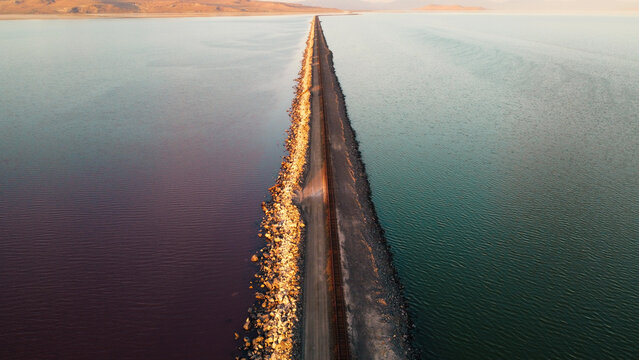 Sunset Aerial Views of the Great Salt Lake Lucin Cutoff Divide Pink Water Contrast with Single Railroad Track Causeway 