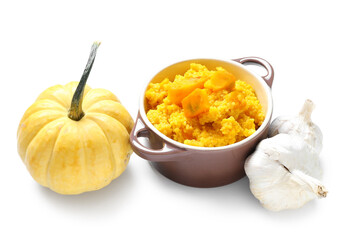 Pot of tasty millet porridge with pumpkin and fresh vegetables on white background