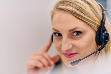 Friendly Call Center Agent Answering Incoming Calls with Headset Providing Remote Customer Service.