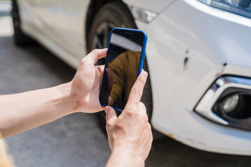 Man fills out a car insurance form after a car accident. Comprehensive motor insurance covers car damage. He files a claim report, speaking with an adjuster to understand his coverage and deductible.