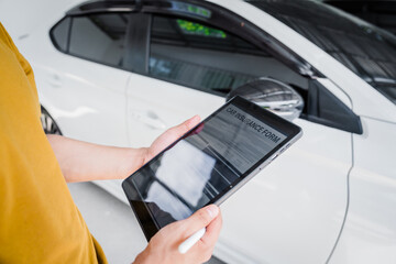Man fills out a car insurance form after a car accident. Comprehensive motor insurance covers car damage. He files a claim report, speaking with an adjuster to understand his coverage and deductible.