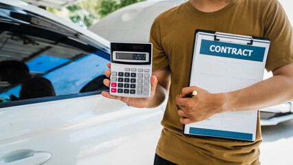 Man fills out a car insurance form after a car accident. Comprehensive motor insurance covers car damage. He files a claim report, speaking with an adjuster to understand his coverage and deductible.