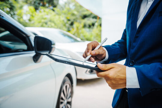 businessman in suit and car auto insurance agent assess car damage, discussing deductible, claims, coverage options comprehensive and collision insurance, completing necessary forms and appraisals.