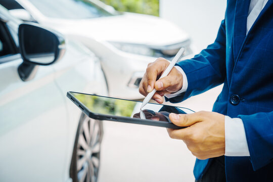 businessman in suit and car auto insurance agent assess car damage, discussing deductible, claims, coverage options comprehensive and collision insurance, completing necessary forms and appraisals.