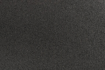 surface of a rubber road hydro pad made from recycled car tires. This new modern building material for street roads and playground.  a close-up texture-filled frame.