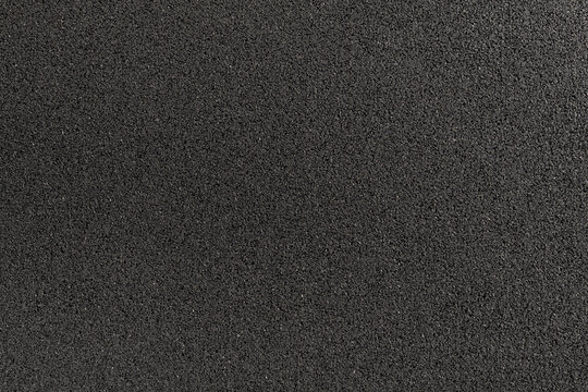 surface of a rubber road hydro pad made from recycled car tires. This new modern building material for street roads and playground.  a close-up texture-filled frame.