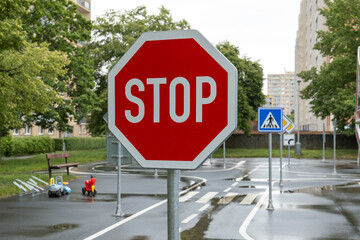 stop road sign on kid's playground designed as a mini road with signs, teaching transportation and...