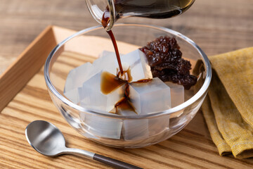 ガラスの器の寒天寄せに黒蜜をかける