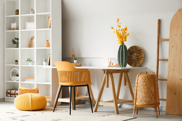 Interior of stylish office with artificial flowers on table