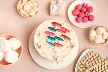 Cake with sweets for birthday party on pink table