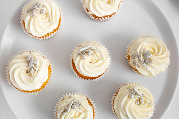 Dessert stand with tasty white cupcakes for birthday party on table