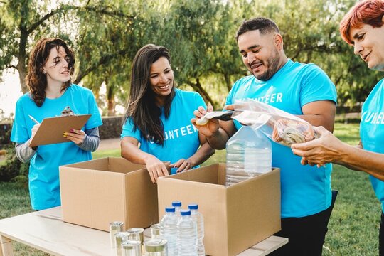 Volunteer people collecting goods and food for community service at park city. Donations and charity project concept