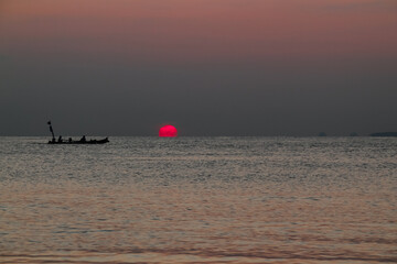 Fototapeta premium Beautiful sunrise on the sea and silhouette of a fishing boat