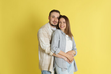 Happy couple hugging on yellow background. Strong relationship