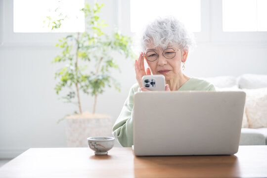 Senior (elderly) women with computers and smartphones (smart phones) who have trouble with presbyopia and operation.