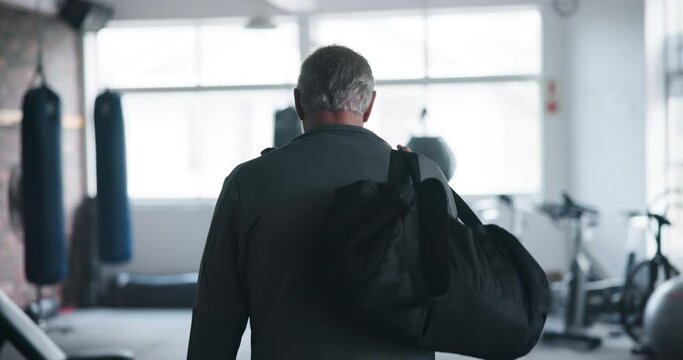 Man, fitness and walking to gym with bag to start exercise, workout or boxing for body wellness. Sport, back view and person enter health club with gear for mature training athlete ready for practice
