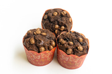 Three chocolate muffin isolated on a white background with copy space. Homemade fluffy and moist chocolate cakes.