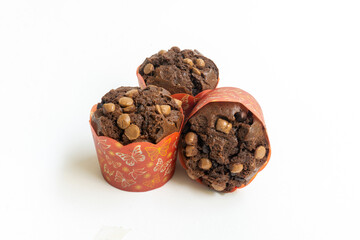 Three chocolate muffin isolated on a white background with copy space. Homemade fluffy and moist chocolate cakes.