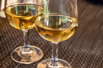 Tasting of Bordeaux white wine in Sauternes, left bank of Gironde Estuary, France. Glasses of white sweet French wine served in restaurant