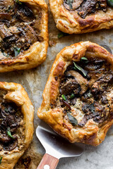 Hot savoury gourmet mushroom pastries on a parchment lined baking sheet.