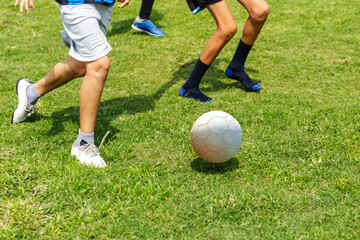 Legs of young soccer players in action on grass