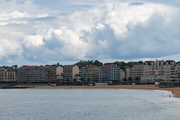 Fototapeta premium Houses and beach in Saint-Jean-de-Luz fishing port on Basque coast, famous resort, known for beautiful architecture, sandy beaches, cuisine, South of France, Basque Country