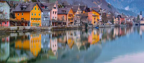 Beautifully colored houses along a lake in Europe, calm water reflecting the vibrant homes. 32k,...