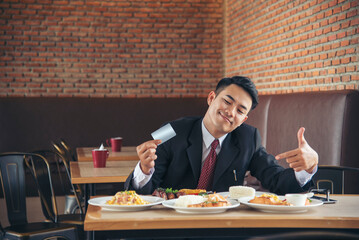 Customer use credit card payment for food at restaurant. Young couple checkout bill and pay via credit to cashier nfc contactless machine.
